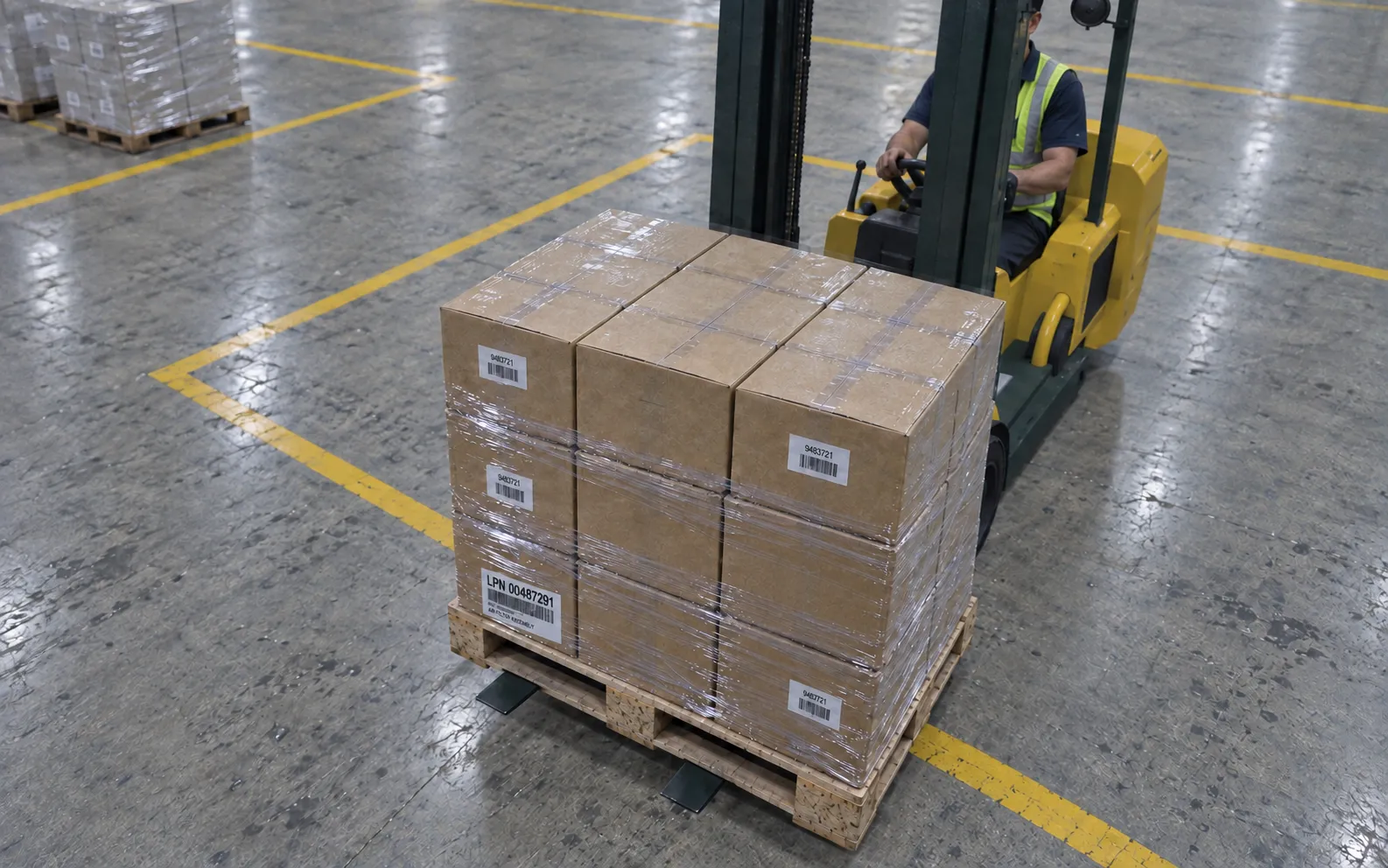 Lower lens on the building-mounted device showing the carton load and shipment label on the approaching forklift.